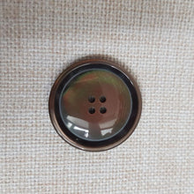 Lataa kuva Galleria-katseluun, Klassinen nelireikäinen läpiommeltava polyesterinappi. Laadukas polyesterimateriaali antaa kauniin helmiäiskiillon nappipinnalle. Kevyt, 4 mm paksuinen, koot 25 mm, 27 mm, 30 mm, 34 mm. Sopii mainiosti miesten ja naisten pikkutakkeihin, villakangastakkeihin ja neuleisiin. Värit helmiäisharmaa ja helmiäisruskea.