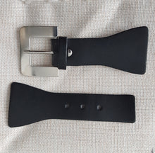 Lataa kuva Galleria-katseluun, Tyylikäs koristesolki joka sopii kiinnikkeeksi Jakkuihin, takkeihin, neuleisiin ja esimerkiksi laukkuihin. Materiaali: tekonahka / metallisolki. Väri: musta / kirkas hopea Nahkaosan pituus 12 cm, levein osa 4 cm, keskeltä 2.5 cm. Metallisoljen koko pituus 11.9 cm, levein osa 4 cm, keskeltä 2.5 cm Soljen paksuus noin 1 cm