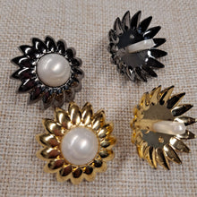 Lataa kuva Galleria-katseluun, Uskomattoman kaunis ja näyttävä kukan muotoinen koristenappi. Nappi on erittäin kevyt, koska se on valmistettu muovista. Kaksiosainen nappi, reunan osa on kulta- tai tummanhopea, keskiosa on valkoista helmiäisväriä. Koko on 29 mm. Nappi sopii erilaisiin neuleisiin, takkeihin, jakkuihin tai sitä voi käyttää koristenappina ja askartelussa.