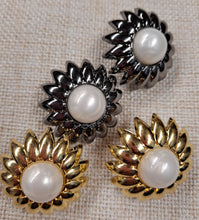 Lataa kuva Galleria-katseluun, Uskomattoman kaunis ja näyttävä kukan muotoinen koristenappi. Nappi on erittäin kevyt, koska se on valmistettu muovista. Kaksiosainen nappi, reunan osa on kulta- tai tummanhopea, keskiosa on valkoista helmiäisväriä. Koko on 29 mm. Nappi sopii erilaisiin neuleisiin, takkeihin, jakkuihin tai sitä voi käyttää koristenappina ja askartelussa.