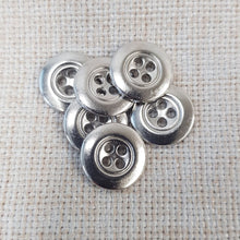 Lataa kuva Galleria-katseluun, Kaunis pieni nelireikäinen metallinappi, jota sanotaan Mari-napiksi. Napin nimitys tulee Marimekon käyttämistä napeista. Tämä on todella ohut metallinappi, jota käytetään hameissa, housuissa, paitapuseroissa ja taskunappina. Käy myös piilonapitukseen. Koot 13 mm ja 15 mm. Värit matta hopea, kirkas hopea, kulta, messinki ja tumma hopea.