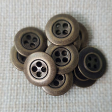 Lataa kuva Galleria-katseluun, Kaunis pieni nelireikäinen metallinappi, jota sanotaan Mari-napiksi. Napin nimitys tulee Marimekon käyttämistä napeista. Tämä on todella ohut metallinappi, jota käytetään hameissa, housuissa, paitapuseroissa ja taskunappina. Käy myös piilonapitukseen. Koot 13 mm ja 15 mm. Värit matta hopea, kirkas hopea, kulta, messinki ja tumma hopea.