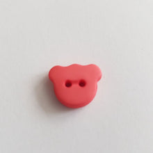 Lataa kuva Galleria-katseluun, Matta pintainen nalle-nappi, 15 mm leveys, läpiommeltava, 2 reikää. Hauska ja värikäs nappi sopii lasten paitoihin, neuleisiin, mekkoihin ja käy koristenapiksi. Kymmenen eri väriä: valkoinen, beige, vaaleanpunainen, keltainen, punainen, oranssi, lila, sinappi, turkoosi, tummansininen, tummanruskea, musta.