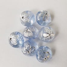 Lataa kuva Galleria-katseluun, Kauniit pienet KUKKA lasten napit. Napin pinnassa on hopea kukka ja nappi ommellaan takaa kiinni. Nappi sopii lasten neuleisiin ja koristeeksi esimerkiksi pipoihin. Napista löytyy viisi väriä: luonnonvalkoinen, vihreä, sininen, ruskea ja lila.