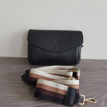 Lataa kuva Galleria-katseluun, Musta SANDRA on arjen varma kumppani. Klassinen musta nahka saa rennon ilmeen beige–ruskea–musta raidallisesta hihnasta, joka tekee laukusta monikäyttöisen ja trendikkään.