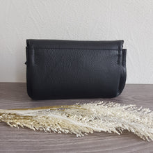 Lataa kuva Galleria-katseluun, Musta SANDRA on arjen varma kumppani. Klassinen musta nahka saa rennon ilmeen beige–ruskea–musta raidallisesta hihnasta, joka tekee laukusta monikäyttöisen ja trendikkään.