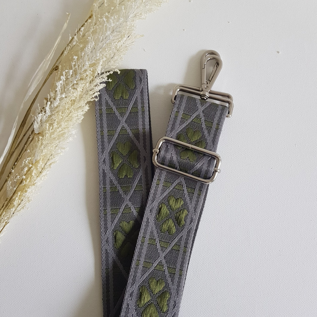 Koristeellinen laukun olkahihna hopeanvärisillä karabiinilukoilla ja ikonisella siksak-kuviolla.  Materiaali: polyesteri ja metalli.  Värit: beige, harmaa, sininen  Koko: säädettävä pituus max. 121 cm, leveys 5cm.  Valmistusmaa Italia