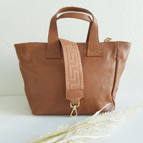 Upea TESSA nahkalaukku, säädettävällä koristehihnalla ja kulta lukoilla.  Laukussa vetoketjulukitus.   Sisältä löytyy avo ja vetoketjullinen piilotasku.   Koko: pituus 37 cm, korkeus 22 cm, syvyys 15cm  Olkahihna leveys 1,5 cm, max pituus 128 cm  leveä koristeellinen polyesteri/ nahka hihna kullanvärisillä pistolukoilla, leveys 5,5 cm, säädettävä pituus max. 128 cm  Valmistusmaa Italia