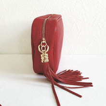 Lataa kuva Galleria-katseluun, ANGIE olkalaukussa on kaksi säädettävää olkahihnaa ja vetoketjukiinnitys. Tupsukoriste toimii vetimenä. Suosittu crossbody malli.  Materiaali: nahkaa  Väri: punainen
