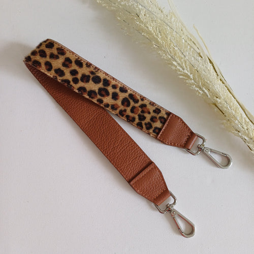 Koristeellinen laukun hihna ruskealla nahkapäällä ja leopardi kuviolla.  Metalliosat hopea  Koko: pituus 61 cm, leveys 4 cm  Valmistusmaa Italia