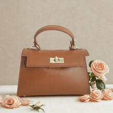 Lataa kuva Galleria-katseluun, Tyylikäs NOE on italialaisesta nahasta valmistettu olkalaukku, jossa yhdistyy klassinen muotoilu ja moderni ilme. Kullanvärinen kääntölukko tuo luksusta jokaiseen asuun, ja sisäpuolelta löytyy vetoketjullinen piilotasku tärkeimmille tavaroille.
