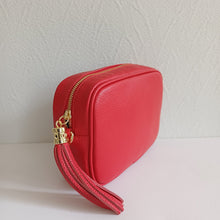 Lataa kuva Galleria-katseluun, ANGIE olkalaukussa on kaksi säädettävää olkahihnaa ja vetoketjukiinnitys. Tupsukoriste toimii vetimenä. Suosittu crossbody malli.  Materiaali: nahkaa  Väri: punainen
