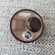 Lataa kuva Galleria-katseluun, Tyylikäs koristeellinen takinnappi &nbsp;34 mm, keskellä kiiltävä emali mihin on upotettu koriste helmet. Sopii mainiosti pitkiin neuleisiin ja takin napiksi.

Napin paksuus 7mm

värit beige ja harnaa

Valmistusmaa Italia
