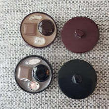 Lataa kuva Galleria-katseluun, Tyylikäs koristeellinen takinnappi &nbsp;34 mm, keskellä kiiltävä emali mihin on upotettu koriste helmet. Sopii mainiosti pitkiin neuleisiin ja takin napiksi.

Napin paksuus 7mm

värit beige ja harnaa

Valmistusmaa Italia
