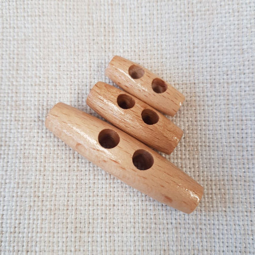 Kaksireikäinen puinen duffelinappi on tarkoitettu näyttävään nyörinapitukseen.  Kolme eri kokoa: 25 mm, 30 mm tai 50 mm.