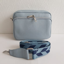 Lataa kuva Galleria-katseluun, Tyylikäs JASMINE nahkalaukku paksulla olkahihnalla.  Laukussa kaksi vetoketjullista taskua hopea lukoilla.  Materiaali: nahka   Koko: pituus 24 cm, korkeus 18cm, syvyys 7,5 cm  Hihna: max pituus 124 cm , hihnan leveys 4,5 cm . Materiaali nahka / polyesteri.  Valmistusmaa Italia
