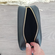 Lataa kuva Galleria-katseluun, ANGIE olkalaukku on aitoa nahkaa. Laukussa on kaksi säädettävää olkahihnaa ja vetoketjukiinnitys. Tupsukoriste toimii vetimenä. Suosittu crossbody malli.  Väri: musta  Koko: pituus 20 cm, korkeus 15 cm, syvyys 7 cm.  Laukkuun kuuluu kaksi säädettävää olkahihnaa:  kapea nahkahihna kullanvärisillä pistolukoilla, leveys 2 cm, säädettävä pituus 130 cm leveä koristeellinen polyesteri/ nahka hihna kullanvärisillä pistolukoilla, leveys 5,5 cm, säädettävä pituus max. 128 cm
