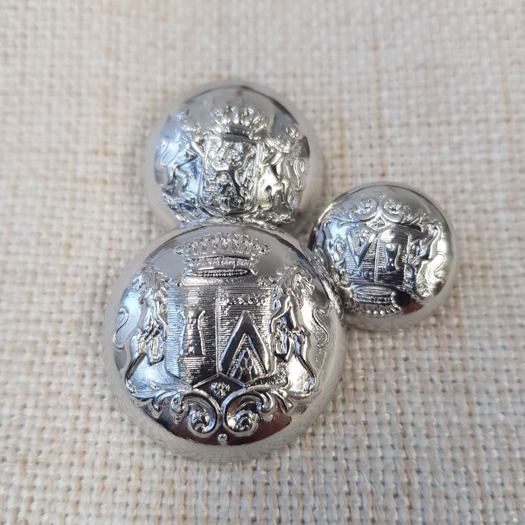 Klassinen metallinen vaakunanappi kannalla, väri kirkas hopea, kolme eri kokoa. Vaakunassa on kaksi leijonaa, kilpi ja kruunu. Sopii klubitakkeihin, erilaisiin irtotakkeihin, bleisereihin ja villatakkeihin.
