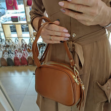 Lataa kuva Galleria-katseluun, Tyylikäs ja tilava konjakinruskea LILY crossbody nahkalaukku  mallinkädessä
