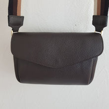 Lataa kuva Galleria-katseluun, SANDRA nahkalaukku on tyylikäs ja käytännöllinen cross body malli säädettävällä koristehihnalla.  Pituus : 23 cm, korkeus 16 cm, syvyys 6 cm  Laukun sisäosa on jaettu kahteen osaan vetoketjullisella taskulla ja sisäosan reunoilta löytyy avotaskut.  Hihna: leveys 5 cm, max pituus 126 cm  Laukun materiaali: nahka; hihna on polyesteria  Valmistusmaa Italia
